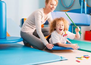 Kid playing with physiotherapist