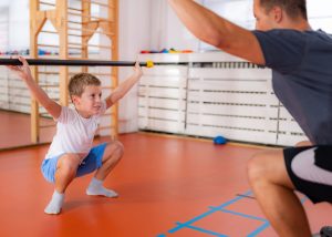 Squats with a bar, strength training and exercise for children