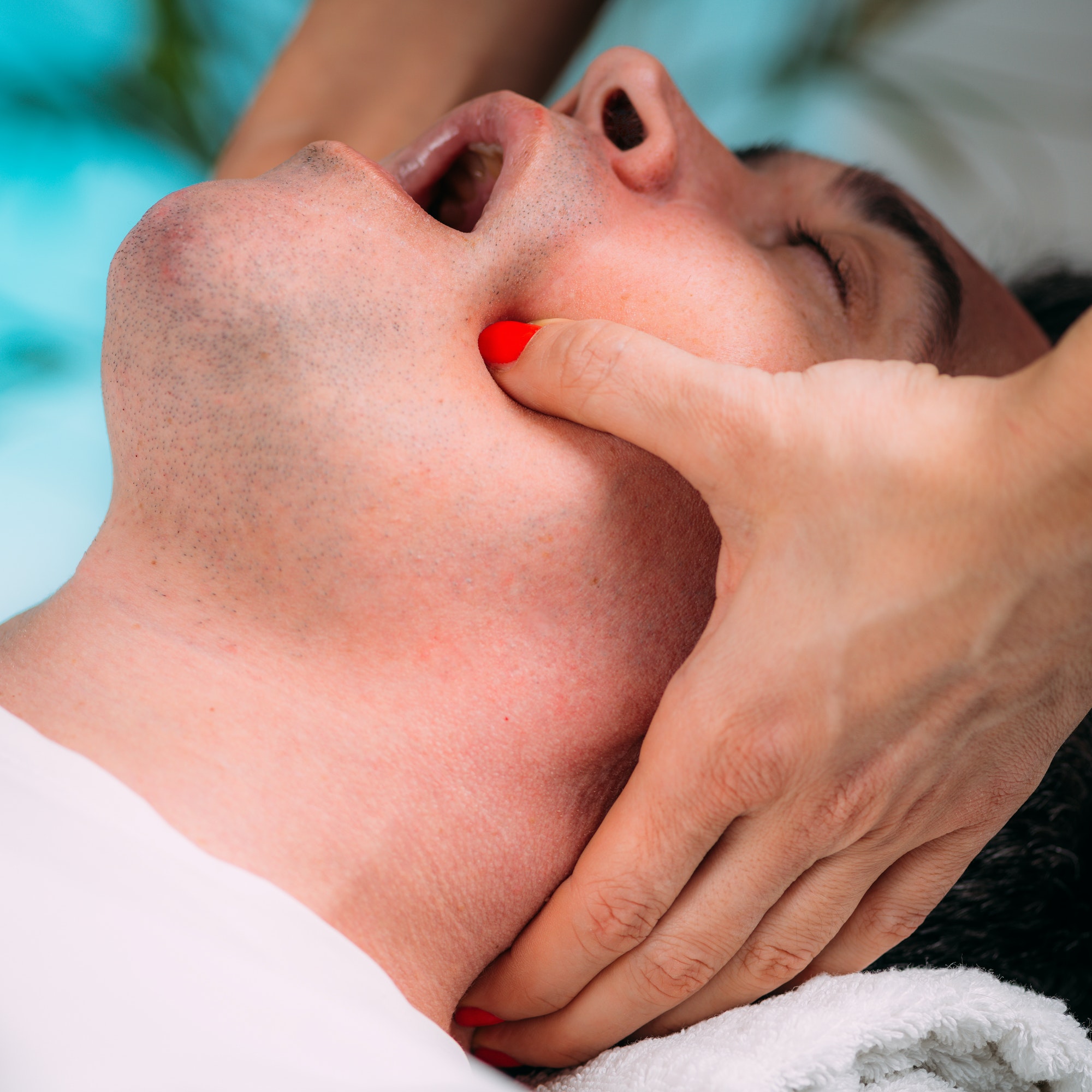 Therapist Massaging Client’s Jaw. Jaw Realignement Massage.