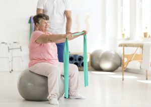 Elderly woman sitting on ball
